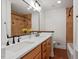 Bathroom with a double vanity, large mirror, and tiled shower with diamond accents at 2114 Woodview Dr, Raleigh, NC 27604