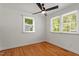 Bedroom featuring hardwood floors, two windows with blinds, and a ceiling fan at 2114 Woodview Dr, Raleigh, NC 27604