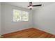 This bedroom features hardwood floors, a window with blinds, and a ceiling fan at 2114 Woodview Dr, Raleigh, NC 27604