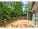 Spacious wooden deck surrounded by lush green trees and black metal railings at 2114 Woodview Dr, Raleigh, NC 27604