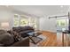 Bright living room with hardwood floors, white walls, and a sliding barn door to an adjacent room at 2114 Woodview Dr, Raleigh, NC 27604