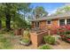 Brick home's backyard featuring a wooden deck, raised garden beds, and mature trees and shrubs at 213 Old Mallard Rd, Smithfield, NC 27577