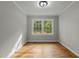 Bright empty room featuring hardwood floors, crown molding, and a double window overlooking the garden at 213 Old Mallard Rd, Smithfield, NC 27577