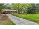 Beautiful single-story home with a brick facade, lush landscaping, and a long driveway leading to a garage at 213 Old Mallard Rd, Smithfield, NC 27577