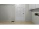 Well-lit laundry room with white cabinets and door, plus neutral walls and tile flooring at 213 Old Mallard Rd, Smithfield, NC 27577