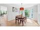 Bright dining area featuring wood floors, an elegant chandelier, and views of the private, wooded backyard at 2169 Rawls Church Rd, Angier, NC 27501