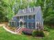 Charming two-story home with a blue exterior, black shutters, a walkway, and a beautifully landscaped front yard at 2169 Rawls Church Rd, Angier, NC 27501