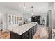Kitchen island with granite countertop, dark wood cabinets and pendant lighting open to the living room at 233 Berg St, Smithfield, NC 27577