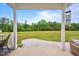 View from a covered porch with a concrete patio and a vast lawn stretching into a wooded area at 233 Berg St, Smithfield, NC 27577