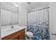 Well-lit bathroom featuring a vanity with a sink, a toilet, and a shower with a floral curtain at 2429 Follow Me Way, Raleigh, NC 27610