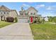 Traditional two-story house featuring neutral siding, a red door, and a nicely maintained front lawn at 2429 Follow Me Way, Raleigh, NC 27610