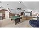 Large game room with ample space, featuring a ping pong table and cozy seating area with media screen at 2429 Follow Me Way, Raleigh, NC 27610