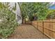 Large, grassy backyard surrounded by a wooden fence and lush greenery at 2615 Bedford Ave, Raleigh, NC 27607