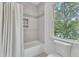 Bright bathroom featuring a tiled shower, tub, toilet and a window with a view at 2615 Bedford Ave, Raleigh, NC 27607
