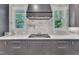 Kitchen range area showcasing the designer hood, marble backsplash, and natural light from the double windows at 2615 Bedford Ave, Raleigh, NC 27607