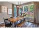 Charming dining area featuring a rustic wooden table, bench seating, and views of the landscaped backyard at 269 Ivy Ridge Rd, Chapel Hill, NC 27516