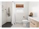 Bathroom featuring a white toilet, wooden vanity, and a window with a bamboo shade at 2702 Richwood Rd, Durham, NC 27705