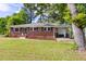 Quaint brick home with a well-kept lawn and an attached carport for convenient parking at 2702 Richwood Rd, Durham, NC 27705