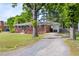 Brick home with a side carport and a driveway, surrounded by mature trees and landscaping at 2702 Richwood Rd, Durham, NC 27705