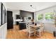 Bright kitchen and dining area with black cabinets, hardwood floors, and natural light at 2702 Richwood Rd, Durham, NC 27705