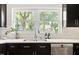Close up of kitchen sink with stainless steel fixtures and window offering a view of the trees at 2702 Richwood Rd, Durham, NC 27705
