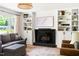 A view of the living room showcases a black fireplace, built-in shelves, and a gray sofa with patterned rug at 2702 Richwood Rd, Durham, NC 27705