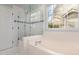 Bright bathroom showcasing a soaking tub and a glass-enclosed shower with tiled walls at 2728 Cherry Field Dr, Raleigh, NC 27603