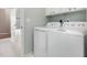 Bright laundry room with white washer and dryer, and tile floors at 2728 Cherry Field Dr, Raleigh, NC 27603