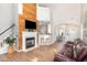 Open living space with brick fireplace, hardwood floors, and barstool seating at 2728 Cherry Field Dr, Raleigh, NC 27603