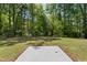 A levelled backyard with a concrete pad and a view of lush greenery, backing to a forest at 2800 Elsa Dr, Raleigh, NC 27610