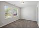 Bedroom with two windows offering natural light, complemented by neutral walls and plush gray carpeting at 2800 Elsa Dr, Raleigh, NC 27610