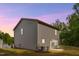 Side and rear exterior showcasing gray siding, neat landscaping, and a dusk sky at 2800 Elsa Dr, Raleigh, NC 27610