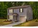 Two-story home with gray siding, black shutters, manicured lawn illuminated by dusk at 2800 Elsa Dr, Raleigh, NC 27610