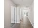 Hallway featuring gray luxury vinyl flooring, white doors, and neutral paint, leading to other rooms at 2800 Elsa Dr, Raleigh, NC 27610