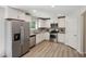 Bright kitchen with white cabinets, stainless steel appliances, granite counters, and hardwood floors at 2800 Elsa Dr, Raleigh, NC 27610