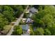 Aerial view showcasing a neighborhood with lush trees, homes with solar panels, and street at 2811 Van Dyke Ave, Raleigh, NC 27607