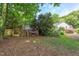 The backyard features lush greenery and a rustic outdoor space for storage and gardening, enhancing its charm at 2811 Van Dyke Ave, Raleigh, NC 27607