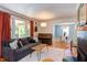 Cozy living room featuring a comfortable sofa, hardwood floors, piano, and view to dining area at 2811 Van Dyke Ave, Raleigh, NC 27607