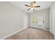 Bright, carpeted bedroom featuring a ceiling fan and access to a balcony with white framed glass doors at 2821 Wilshire Hill Dr # 111, Raleigh, NC 27604
