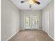 Bright, carpeted bedroom featuring a ceiling fan and access to a balcony with white framed glass doors at 2821 Wilshire Hill Dr # 111, Raleigh, NC 27604