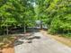 View of the front exterior, showcasing the house nestled among lush trees and the driveway at 2901 Horse Shoe Farm Rd, Wake Forest, NC 27587