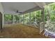 Spacious covered porch featuring columns, latticework railing, and tiled flooring with a wooded view at 2901 Horse Shoe Farm Rd, Wake Forest, NC 27587