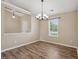 Cozy dining area featuring wood floors, a modern chandelier, and natural light at 308 Holly Briar Dr, Fuquay Varina, NC 27526
