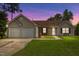 Charming single-story home featuring a well-manicured lawn, two-car garage, and lovely facade at twilight at 308 Holly Briar Dr, Fuquay Varina, NC 27526