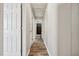 Hallway with wood-look flooring, white doors, and access to bathroom at 308 Holly Briar Dr, Fuquay Varina, NC 27526