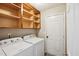 Functional laundry room with shelving above washer and dryer at 308 Holly Briar Dr, Fuquay Varina, NC 27526