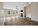 Spacious living room featuring three windows, a fireplace, a ceiling fan, and wood-look floors at 308 Holly Briar Dr, Fuquay Varina, NC 27526