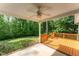 Inviting covered porch boasting a ceiling fan and wooden railings, ideal for outdoor relaxation and enjoying the wooded scenery at 315 Copper Ridge Dr, Sanford, NC 27330