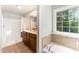The main bathroom offers a tiled floor, double vanity, large garden tub, a separate shower, and a window at 315 Copper Ridge Dr, Sanford, NC 27330