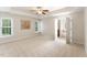 Bright main bedroom features neutral walls, carpet, multiple windows, and an open door to the main bathroom at 315 Copper Ridge Dr, Sanford, NC 27330